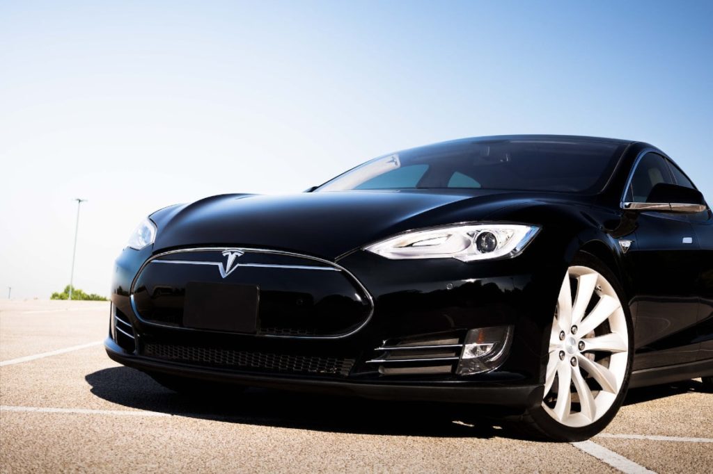 Svart Tesla elbil parkerad på ett asfalterat underlag