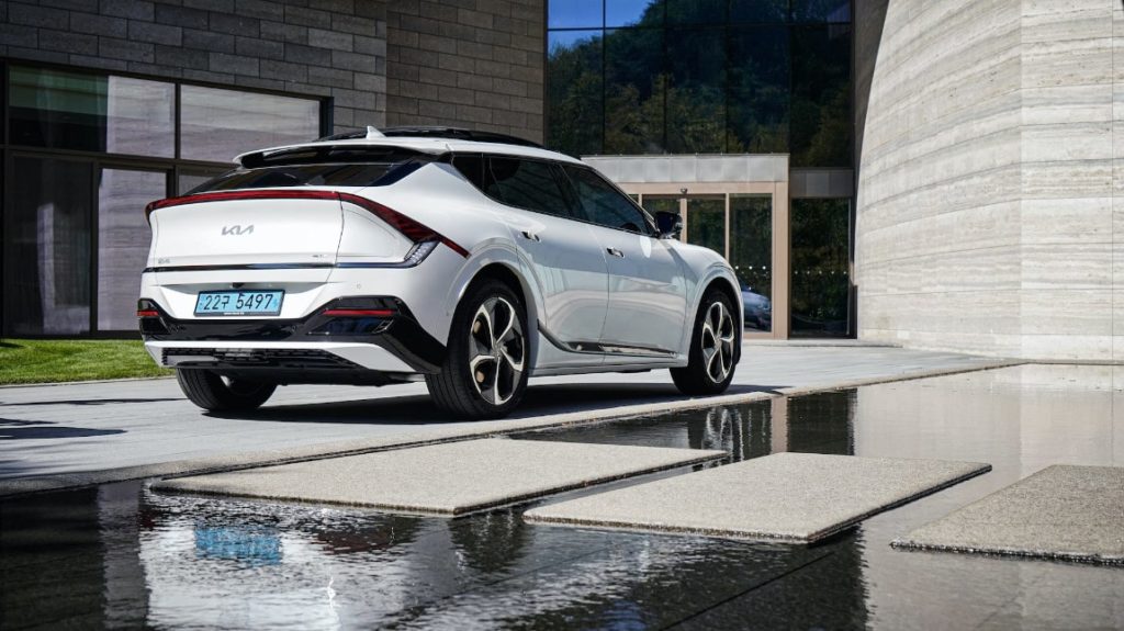Vit Kia EV6 parkerad utanför ett byggnad i modern arkitekturstil
